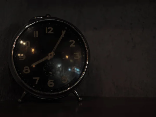 Closeup of an old analogue clock in the dark. Selected focus.
