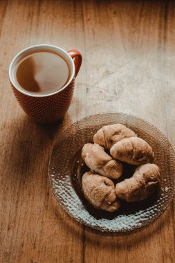 Romantik bir kitap okumak için çayla birlikte lezzetli kruvasanlar.