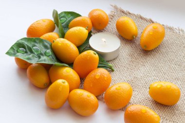 Spa çiy damlaları ve bir mum ile mandalina yaprakları bir dizi oluşur. Her şey güzel bir çuval arka plan üzerine serilir.