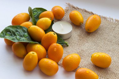 Spa çiy damlaları ve bir mum ile mandalina yaprakları bir dizi oluşur. Her şey güzel bir çuval arka plan üzerine serilir.