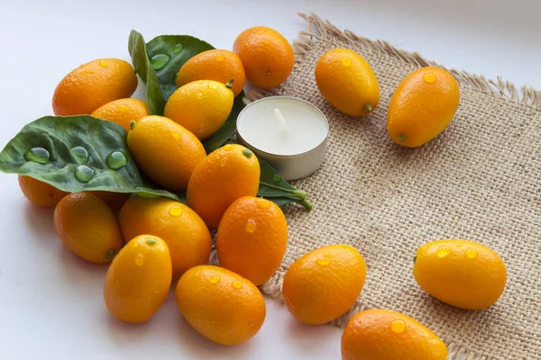 Spa çiy damlaları ve bir mum ile mandalina yaprakları bir dizi oluşur. Her şey güzel bir çuval arka plan üzerine serilir.