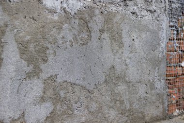 Duvarda kafes ve işaretlerden oluşan çimento şap. İnşaat geçmişi. Evin onarımı.