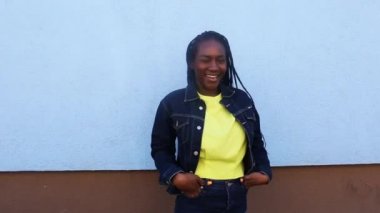 Afrikalı örgü saçlı kız kameranın önünde dönüyor.