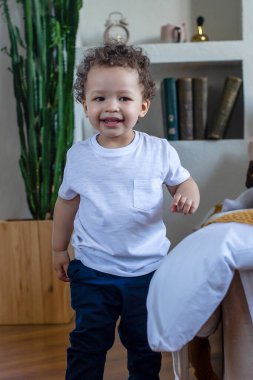 Mutlu kıvırcık saçlı çocuk evde.