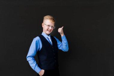 Siyah arka plandaki mutlu okul çocuğu, iyi görünüyor.