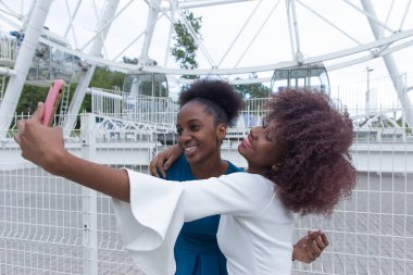 İki Afrikalı Amerikalı kadın selfie çekiyor.