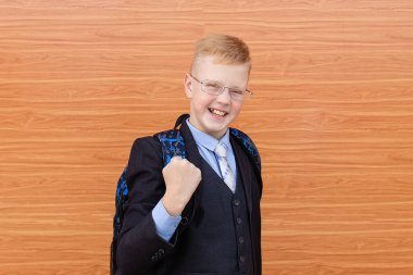 Sokakta takım elbiseli neşeli okul çocuğu.