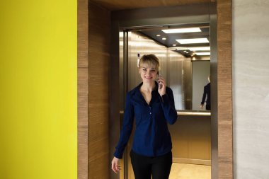 İş yerindeki iş sarışını, telefonu olan.