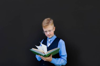 Okul çocuğu okul yönetim kurulunun yanında okuyor.