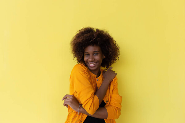 The beautiful and happy African American on a yellow background