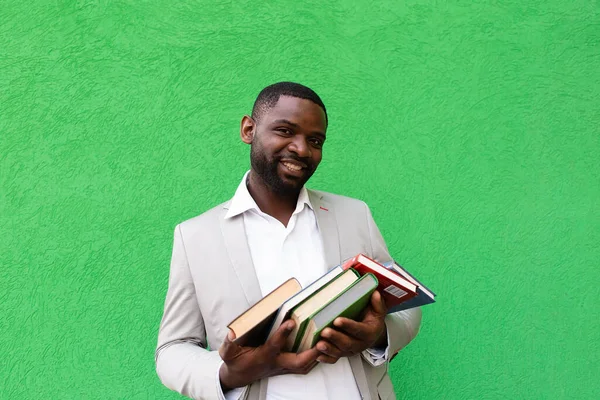 the African American student with a book on a green background