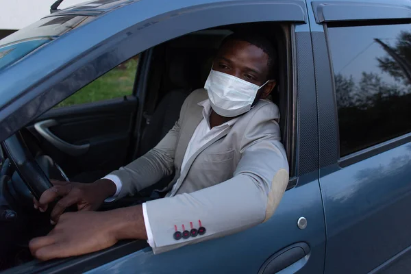 the African American in protective mask in car