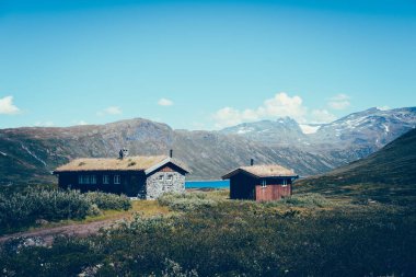 Oppland, Norveç için Jotunheimen Milli Parkı manzara. Eski geleneksel Norveç kulübe bir dağ Gölü ve arka planda bir dağ deniz kenarı.