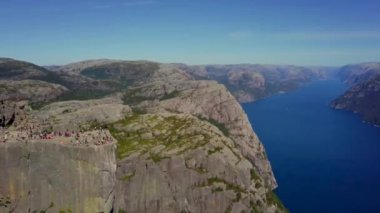 Norveç 2018: Stavanger yakınlarındaki Lysefjord 'un kıyısındaki preikestolen - ünlü yürüyüş noktası. Yazın pek çok turist kıyıda fotoğraf çekiyor..