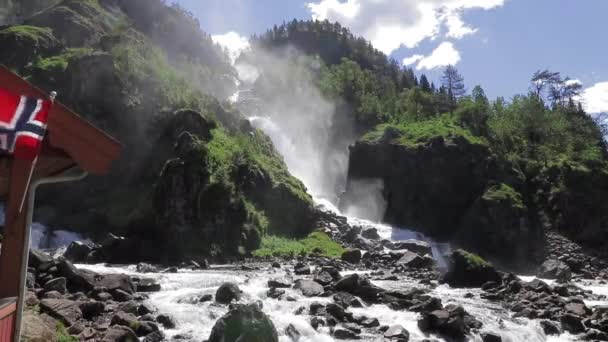 日当たりの良い夏の日にノルウェーの Langfossen 滝があります ノルウェー国旗はフレームの左側に風で飛んでる — ストック動画