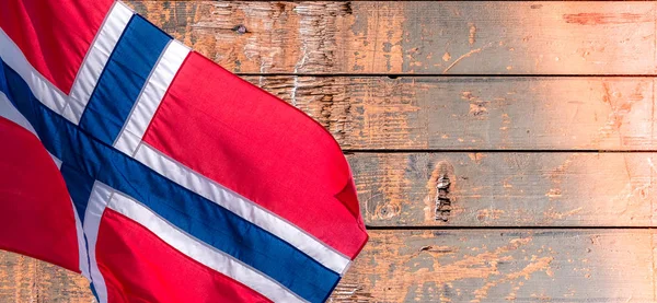 Banner with waving Norwegian flag on the old wooden pattern background with copy space