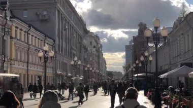 Arbat Moskova şehir merkezinde bir yaya caddesi üzerinde yürüyen insanlar. Moody gökyüzü günbatımı başında.