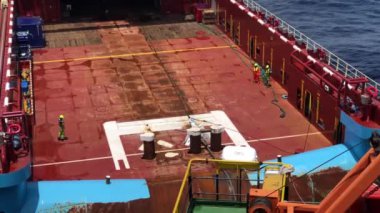 Bir offshore destek gemisinin güverte mürettebatı bir geminin güvertesinde bir çekme ekipman hazırlıkları yapan