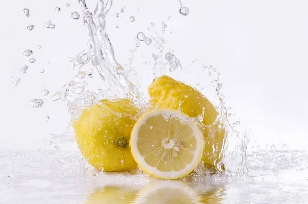 Limones amarillos con agua salpicada — Foto de Stock