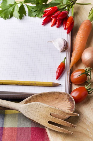 recipe book with vegetables and spices in the foreground