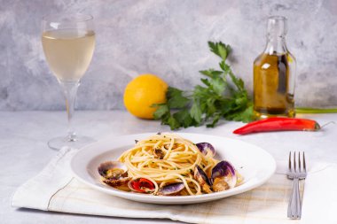 Ön planda, gri bir arka planda, istiridyeli güzel kokulu spagetti tabağı.