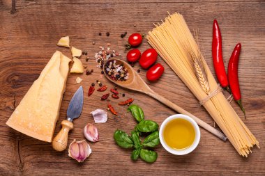 Tahta, çiğ spagetti, baharatlı Grana Padano peyniri, sarımsak, yağ ve aromatik bitkilerle birlikte sayısız malzeme. Yukarıdan görüntüle