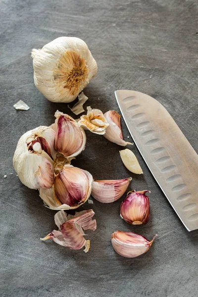 Een Grijze Achtergrond Textuur Bol Teentjes Knoflook Met Mes Stilleven — Stockfoto