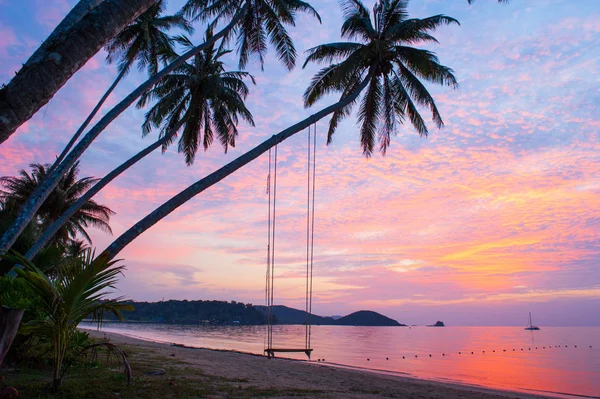Rustige tijd, mooie wolken en zonsondergang hemel. Swing en kokospalmen voorgrond, baai en jacht achtergrond. Zomerseizoen. — Stockfoto