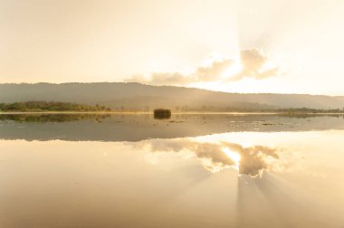 Yaz geliyor. Güneş, l etrafındaki bulutların arasından parlar.