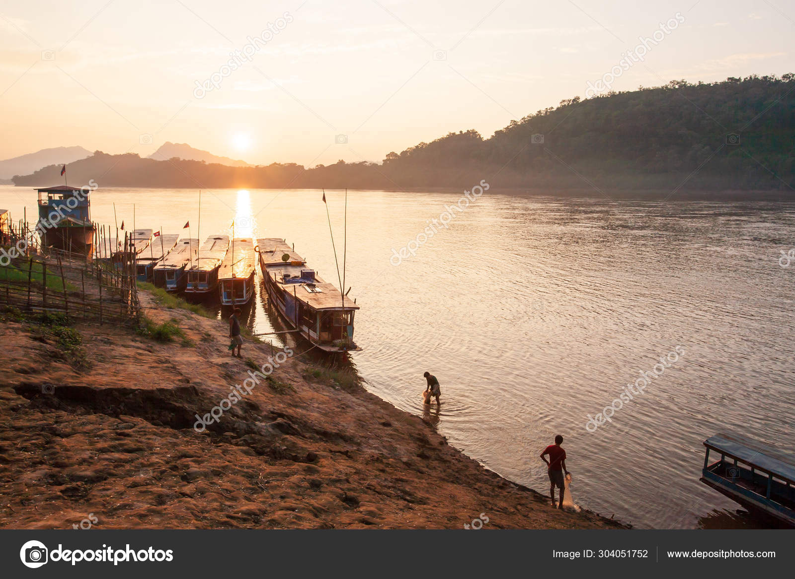 Лаосский Рыбак С Рыболовецкими Сетями В Реке Меконг На Закате.