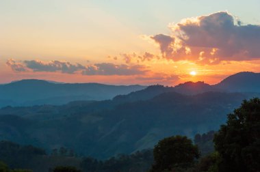 Dağ sırası üzerinde altın güneş batıyor.