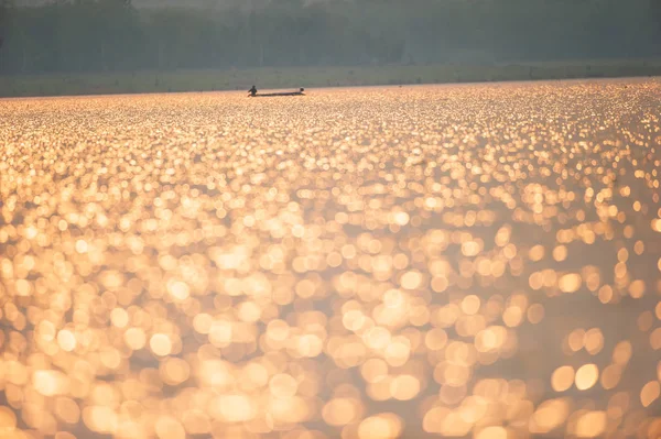 Un asiatico pescatore sul lago incandescente al tramonto . — Foto Stock