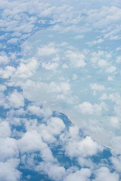 Вид с воздуха на голубое небо и волнистые облака из окна самолета
.