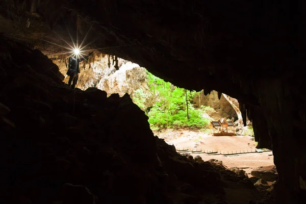 Joven explorando la cueva misteriosa con una antorcha . —  Fotos de Stock