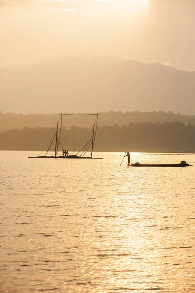 Fisherman on fishing boat in the lake at dusk. — Stock Fotó