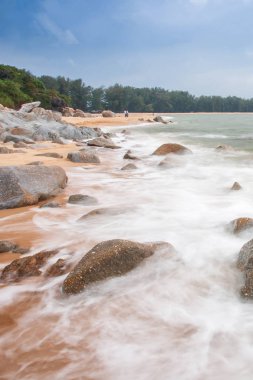 Alacakaranlıkta tropikal sahilde nazikçe dalgalar..