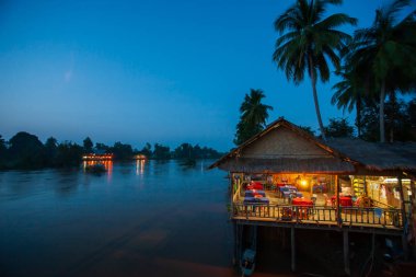 Alacakaranlıkta Mekong Nehri 'ndeki yerel bir restoran..
