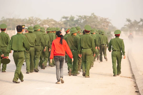 Gadis remaja berbaju merah berjalan dengan sekelompok tentara muda Vietnam . — Stok Foto