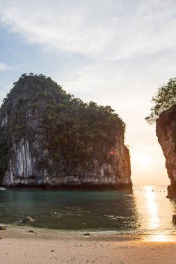 Sabahın ilk ışıklarındaki tropik plaj manzarası.