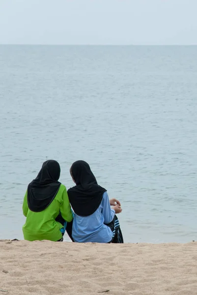 Dos asiático musulmán secundaria adolescente niñas relajarse en la playa en la mañana . — Foto de Stock