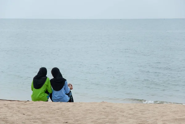 Dos asiático musulmán secundaria adolescente niñas relajarse en la playa en la mañana . — Foto de Stock