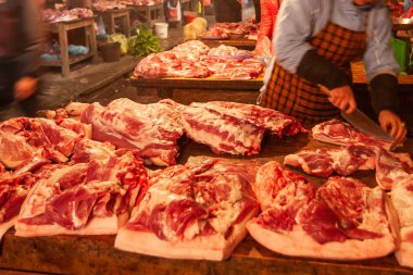 Kadın kasap kasapta eti küçük parçalara ayırıyor..