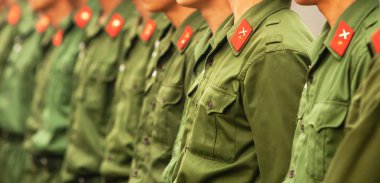 Arka arkaya yeşil üniformalı genç Vietnamlı erkek asker, kırmızı sta