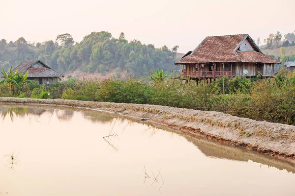Malownicza wieś Wietnamu o zachodzie słońca, dwa stare drewniane domu, brązowy e — Zdjęcie stockowe