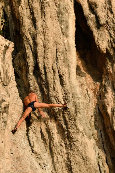 Vieil homme grimpeur sans filet accroché dans la falaise avec son — Photo