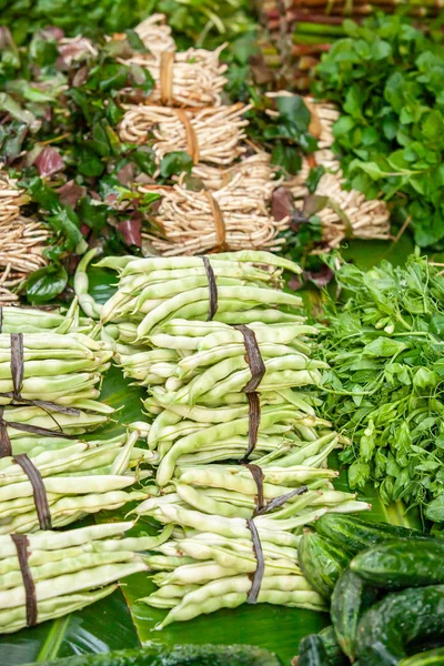 Frische und üppige Erbsen und anderes Gemüse auf Bananenblättern. — Stockfoto