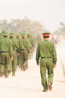 A group of Young Vietnamese soldier walking on the street. clipart