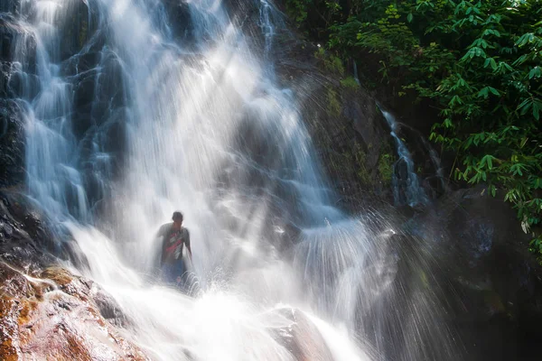 Heureux les jeunes hommes se détendre sous la cascade dans la nature . — Photo