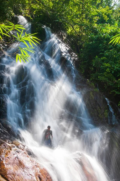 Boldog fiatalember pihen a vízesés alatt a természetben. — Stock Fotó