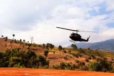 Askeri helikopter vadiye, teras tarlalarına ve dağlara iniyor..
